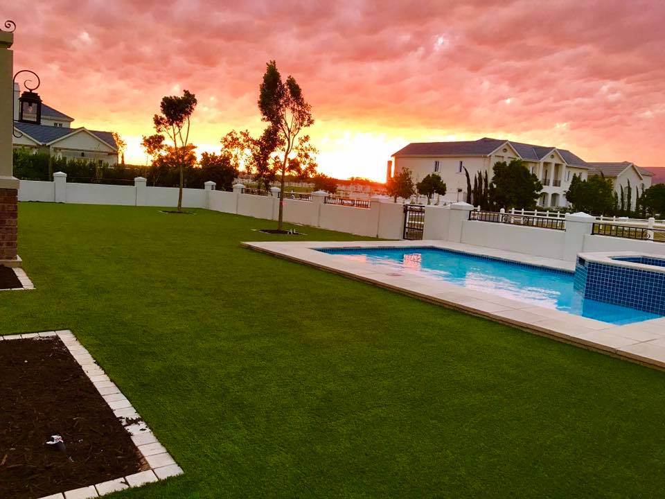 Artificial grass installation by a swimming pool